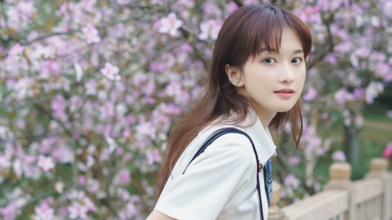 桃花树下制服美女清新脱俗图片