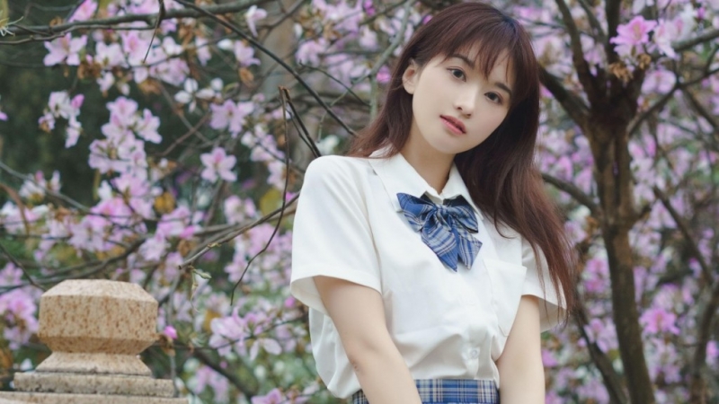 桃花树下制服美女清新脱俗图片