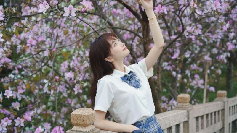 桃花树下制服美女清新脱俗图片