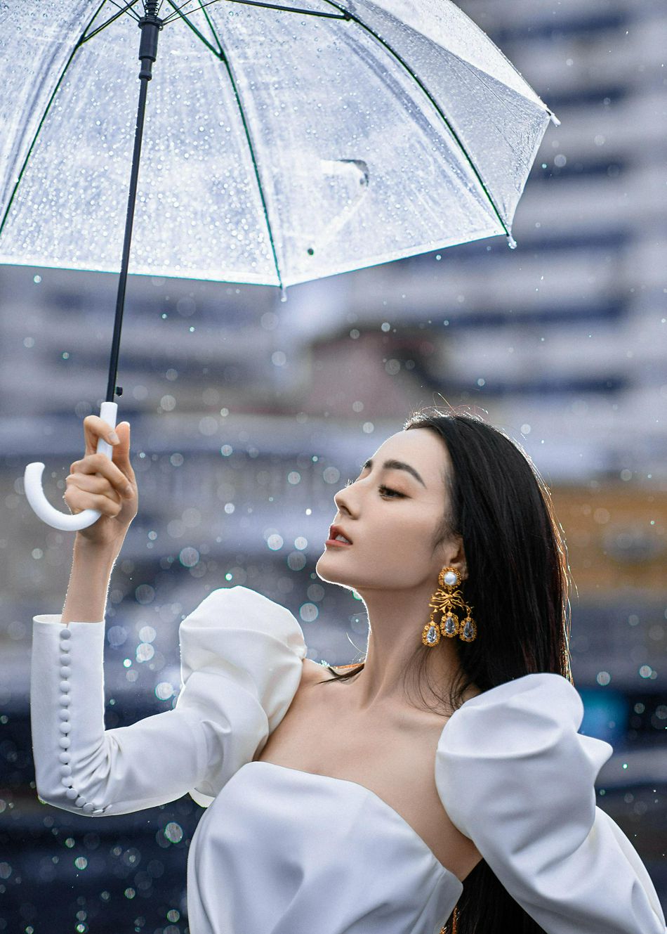 迪丽热巴撑伞漫步雨中优雅迷人