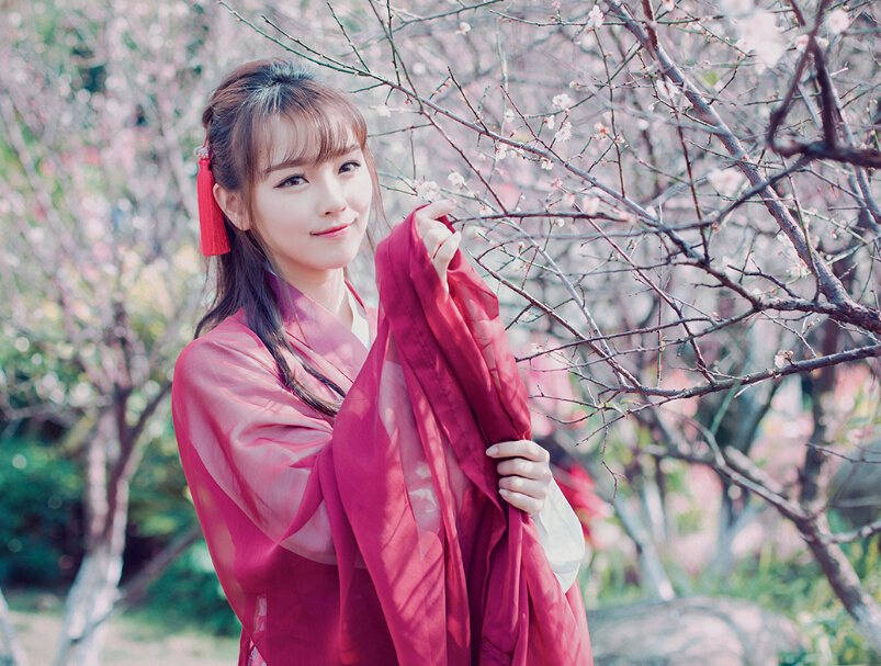 红衣少女户外赏梅图片  五官清秀