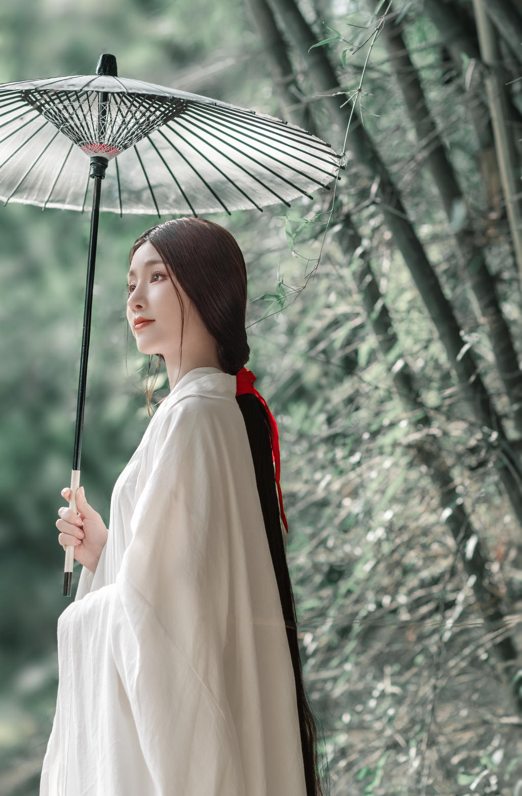 撑着油纸伞的白衣美女竹林写真