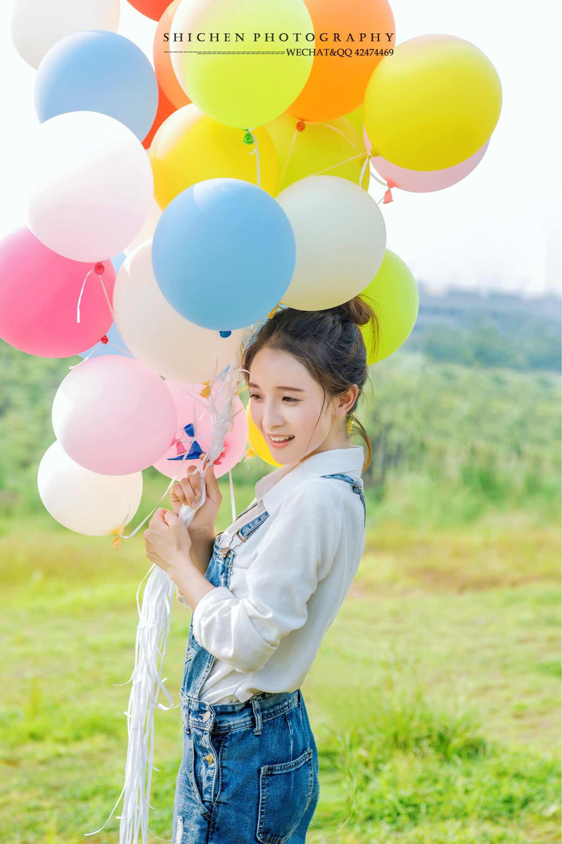 玩气球的牛仔裤背带女孩