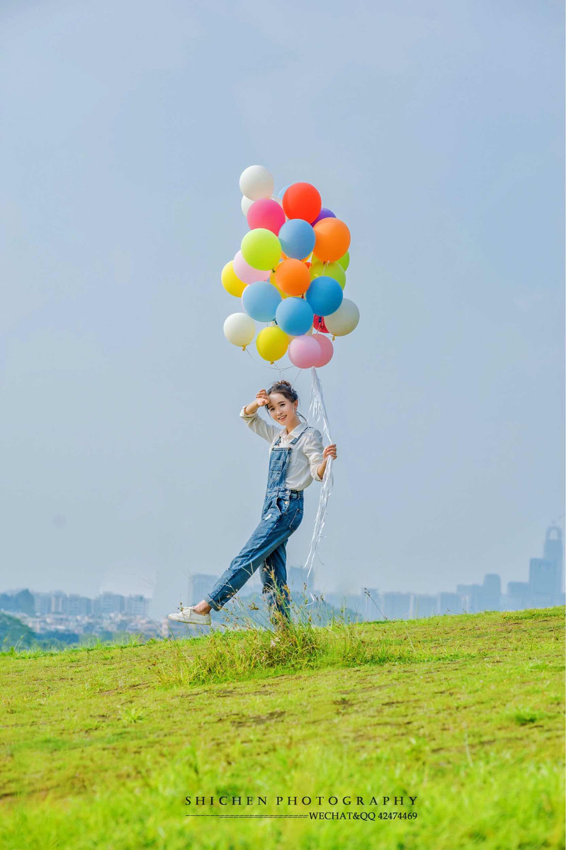 玩气球的牛仔裤背带女孩