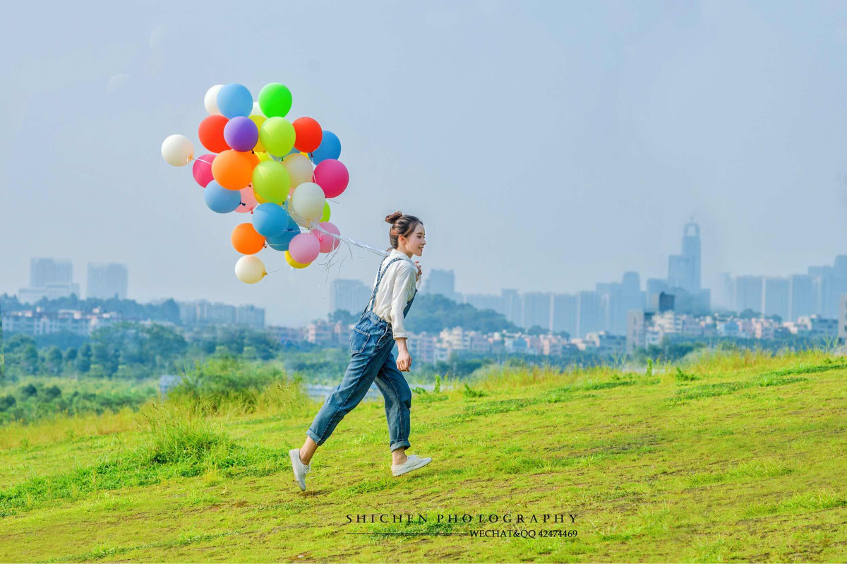 玩气球的牛仔裤背带女孩