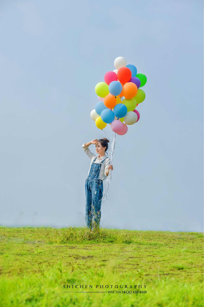玩气球的牛仔裤背带女孩