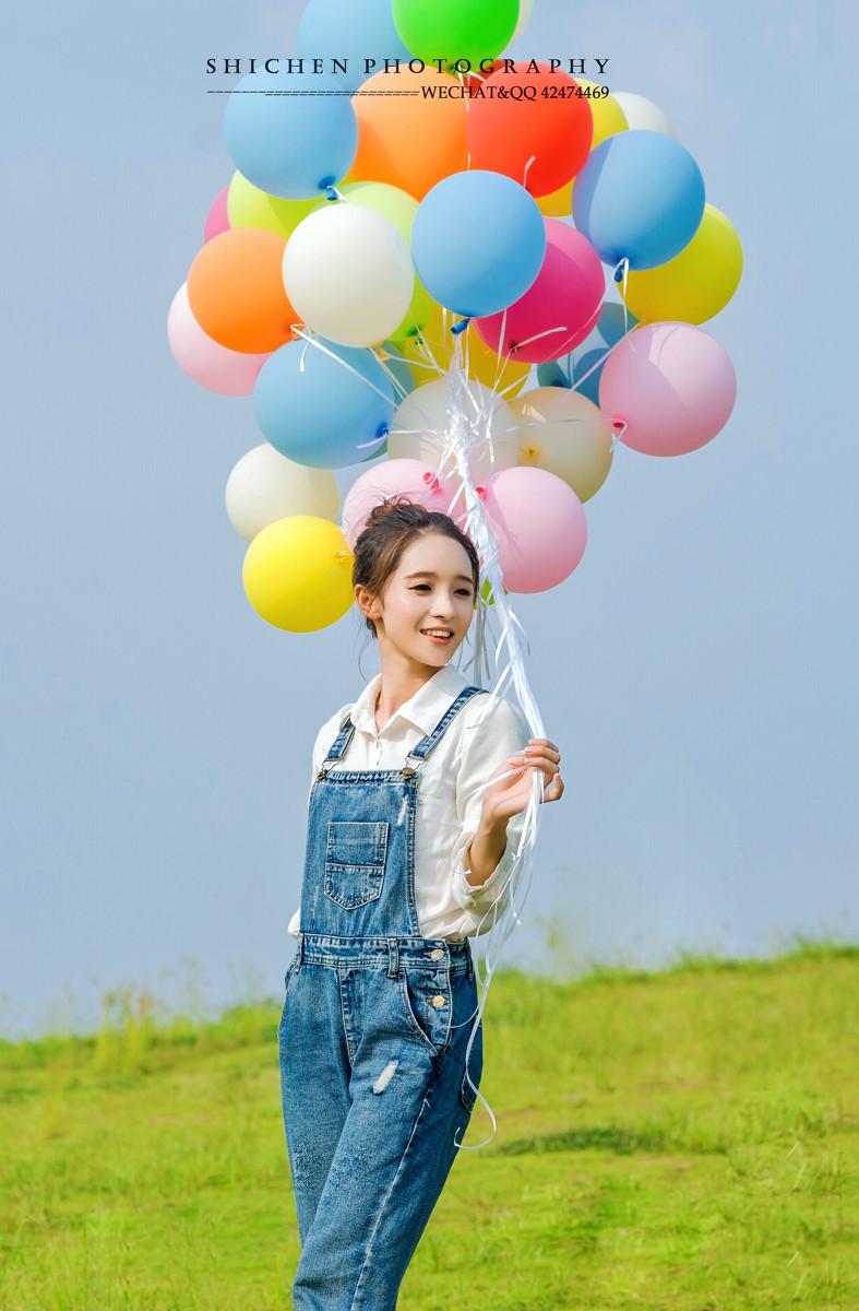 玩气球的牛仔裤背带女孩